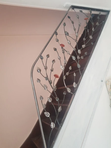 Rampe d'escalier fer forgé et rose en cuivre réalisées à la main à FOUGÈRES SUR BIÈVRE